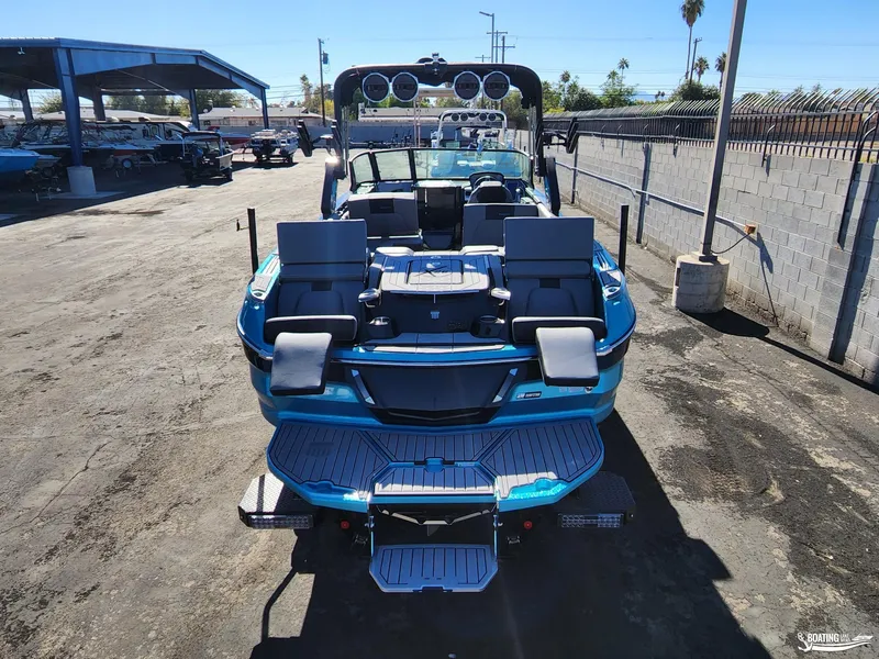 Slide: The Image of 2023 MasterCraft X26 boat, rear view, in a marina setting. - 22