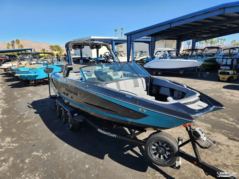 Slide: The Image of 2023 MasterCraft X26 boat on trailer in sunny dealership lot. - 3