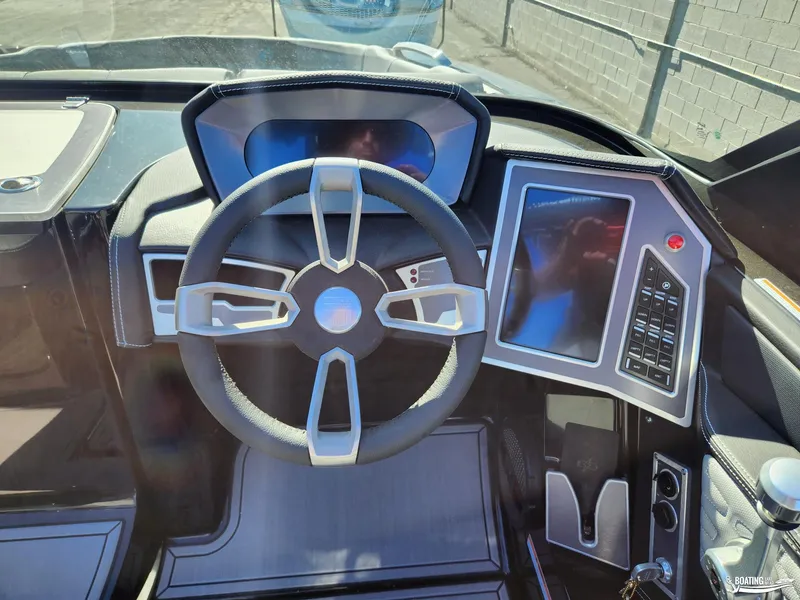 Slide: The Image of 2023 MasterCraft X26 boat dashboard with steering wheel and touchscreen controls. - 6