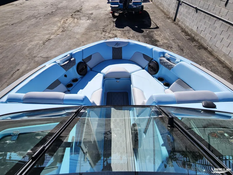 Slide: The Image of 2023 MasterCraft XT23 boat with spacious blue seating and modern design. - 12