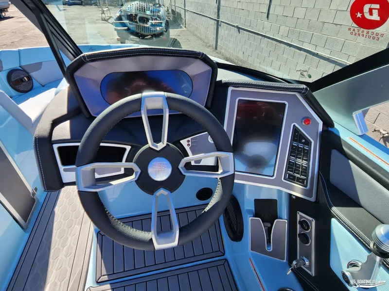 Slide: The Image of 2023 MasterCraft XT23 boat dashboard with modern steering wheel and digital controls. - 13