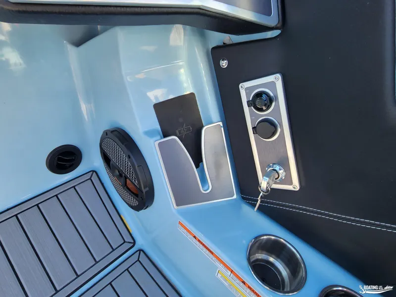 Slide: The Image of 2023 MasterCraft XT23 boat interior with speaker, cup holder, and control panel. - 14