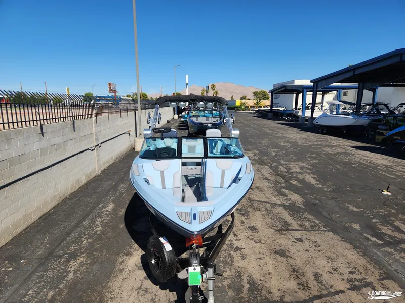 Slide: The Image of 2023 MasterCraft XT23 boat in a dealership lot, front view. - 2