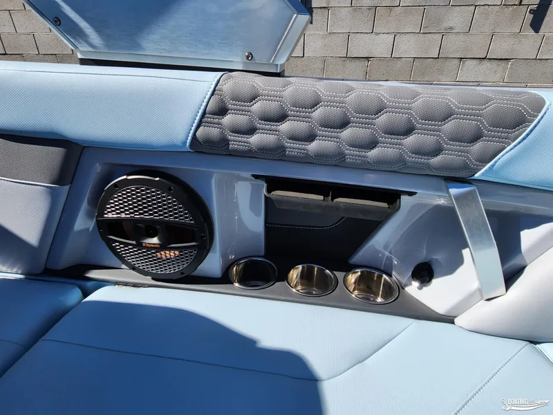 Slide: The Image of 2023 MasterCraft XT23 interior with speaker, cup holders, and stylish upholstery. - 21