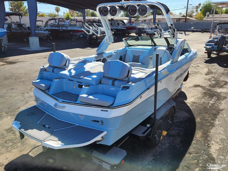 Slide: The Image of 2023 MasterCraft XT23 boat with blue and white interior, parked on a trailer. - 4