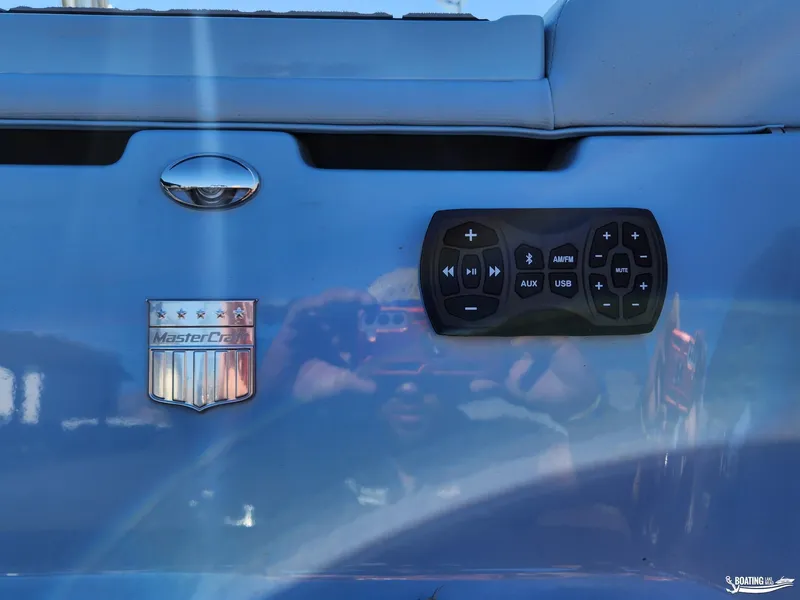 Slide: The Image of 2023 MasterCraft XT23 boat control panel with audio system buttons. - 6