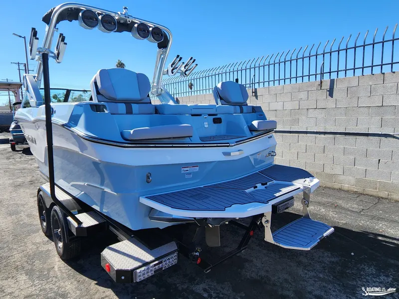 Slide: The Image of 2023 MasterCraft XT23 boat on trailer, rear view, in a parking lot. - 7