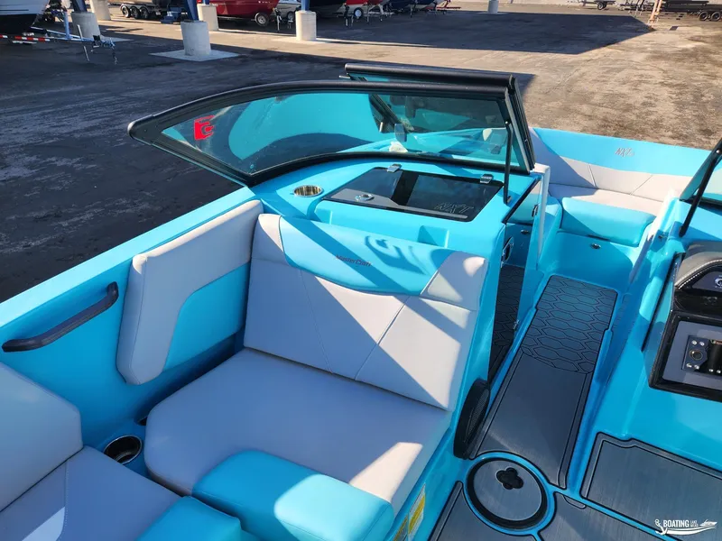 Slide: The Image of 2023 MasterCraft NXT20 boat interior with blue and gray seating, docked at marina. - 11