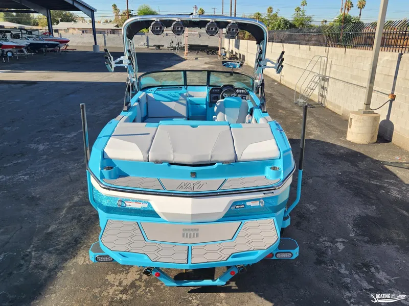 Slide: The Image of 2023 MasterCraft NXT20 boat, blue and white, parked in a marina. - 20