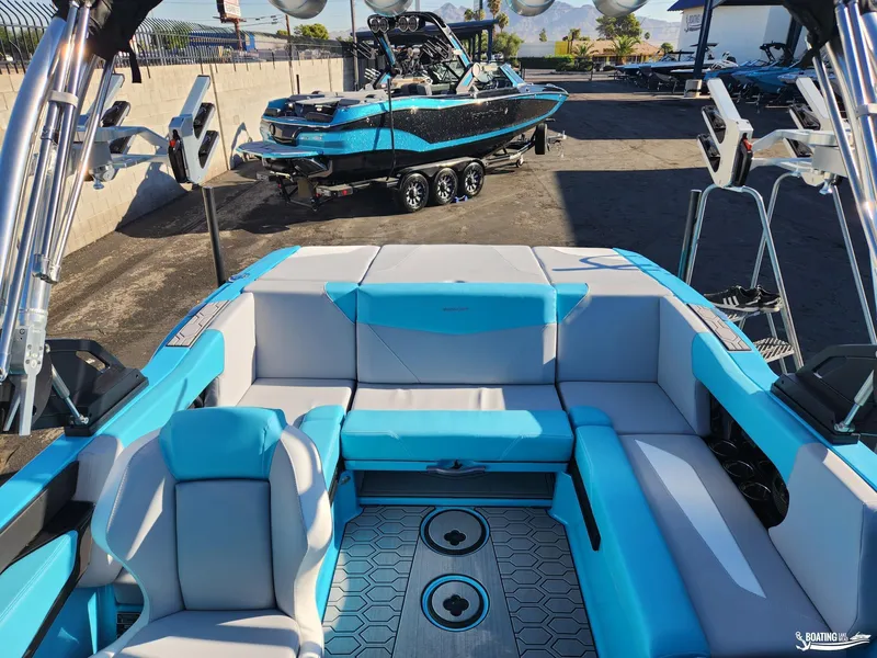 Slide: The Image of 2023 MasterCraft NXT20 boat interior with blue and gray seating, docked outdoors. - 5
