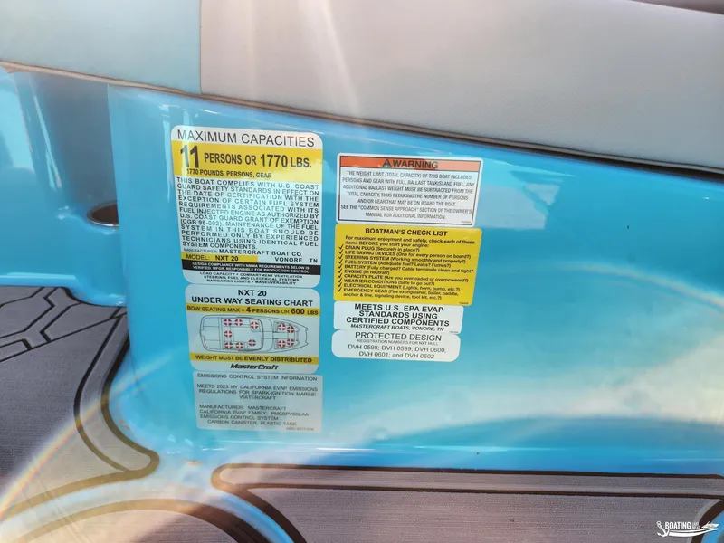 Slide: The Image of 2023 MasterCraft NXT20 capacity and safety labels on blue interior. - 9