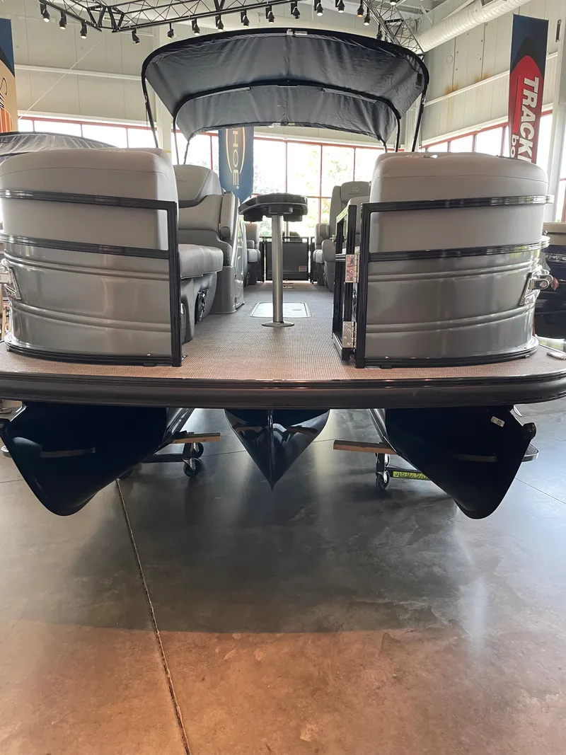 Slide: The Image of 2023 Regency 230 LE3 pontoon boat displayed indoors. - 2