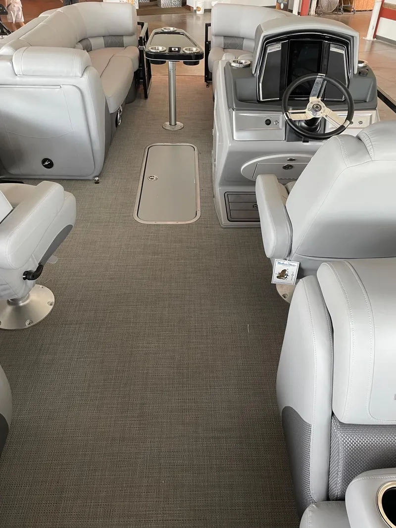 Slide: The Image of 2023 Regency 230 LE3 pontoon boat interior with gray seating and steering console. - 4
