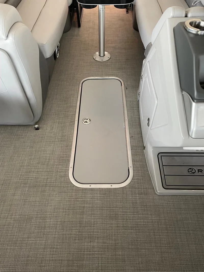 Slide: The Image of 2023 Regency 230 LE3 boat interior with storage compartment and seating. - 6