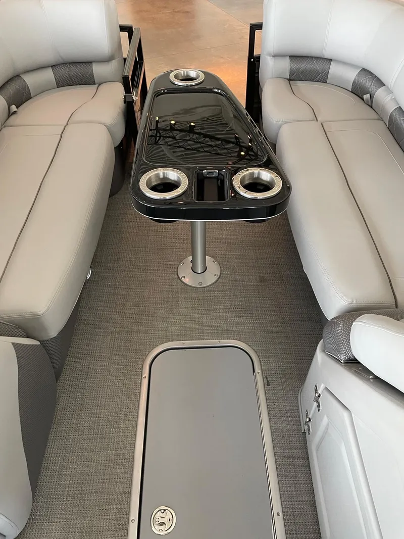 Slide: The Image of 2023 Regency 230 LE3 boat interior with plush seating and a central table. - 9