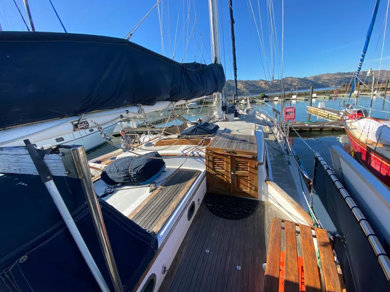Slide: The Image of 1979 CT 48 sailboat deck with wooden details, docked at a marina under clear blue skies. - 11