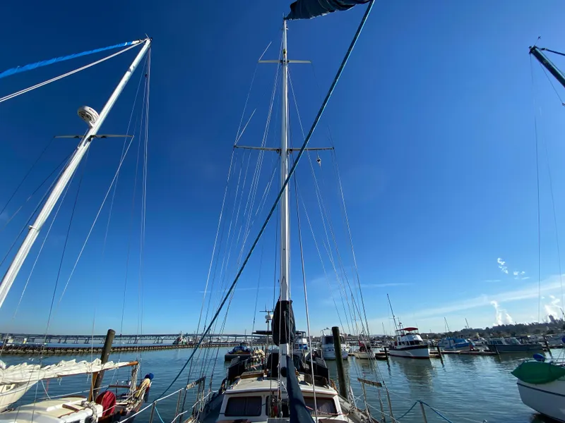 Slide: The Image of Sailboats docked in a marina under a clear blue sky, featuring a 1979 CT 48. - 14
