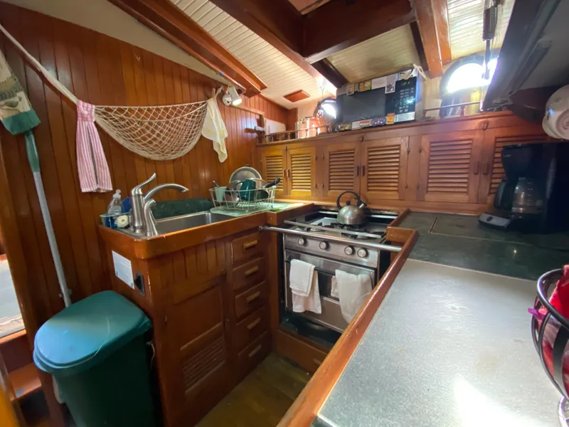 Slide: The Image of 1979 CT 48 yacht kitchen with wooden cabinetry, stove, and sink. Cozy maritime interior design. - 23