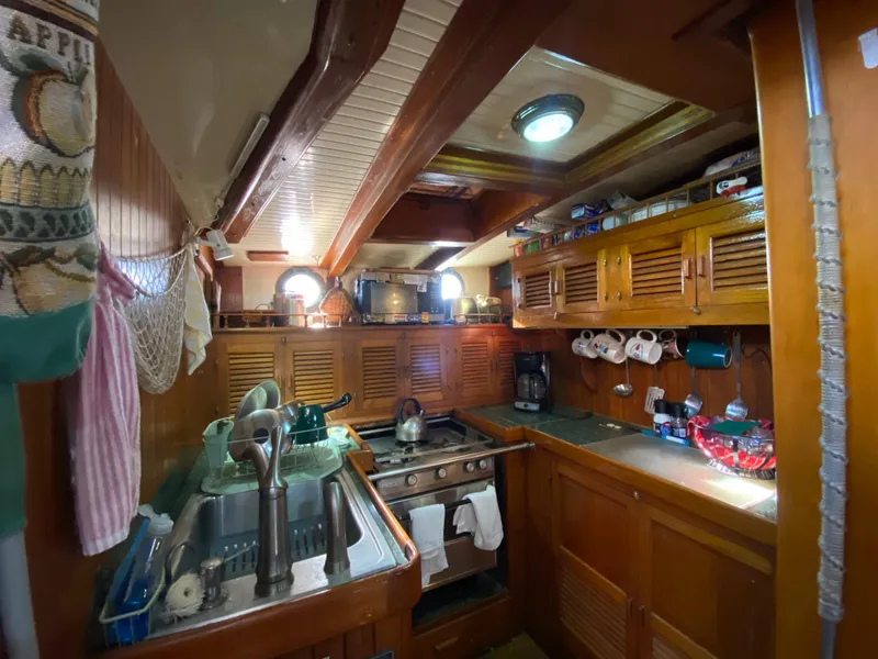 Slide: The Image of 1979 CT 48 yacht kitchen with wooden cabinets, stove, and sink. Cozy maritime interior. - 24