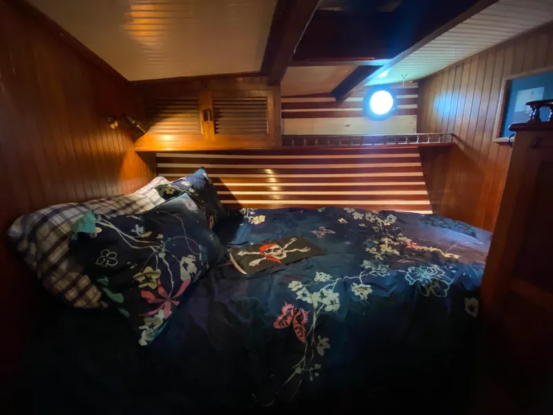 Slide: The Image of Cozy wooden cabin interior with floral bedding, featuring a porthole window and warm lighting. - 25