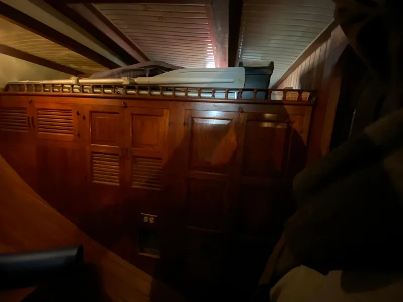 Slide: The Image of Wooden interior of a 1979 CT 48 boat, featuring cabinets and a cozy sleeping area. - 28