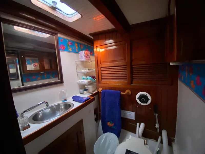 Slide: The Image of 1979 CT 48 yacht bathroom with wooden cabinets, sink, and nautical decor. - 29