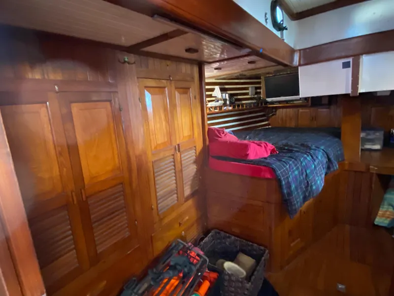 Slide: The Image of Cozy wooden cabin interior of a 1979 CT 48 boat with bed and storage. - 32