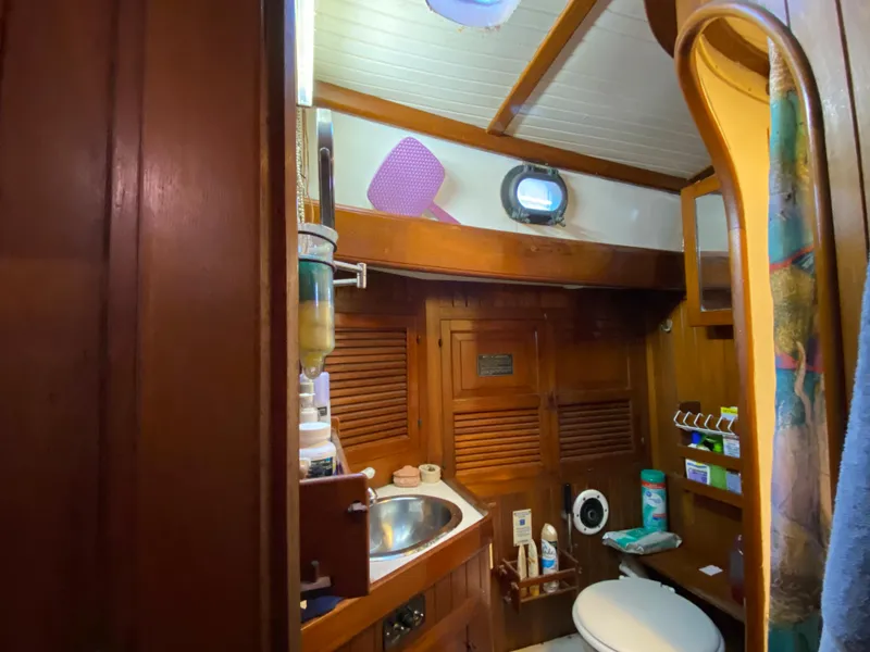 Slide: The Image of 1979 CT 48 yacht bathroom with wooden interior, sink, and porthole window. - 36