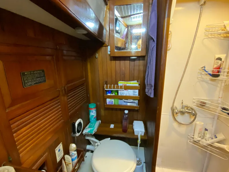 Slide: The Image of 1979 CT 48 yacht bathroom with wooden cabinetry, mirror, and shower area. - 37