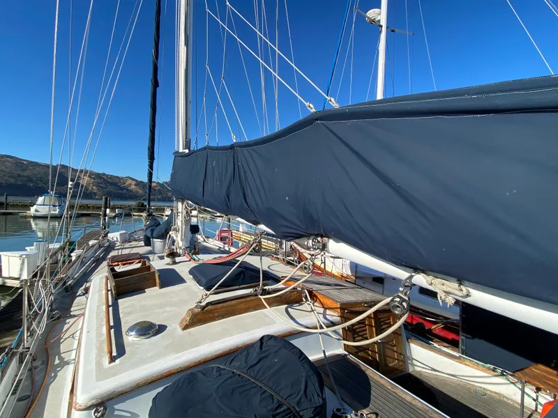 Slide: The Image of 1979 CT 48 sailboat deck with blue cover, docked in a marina under clear skies. - 9