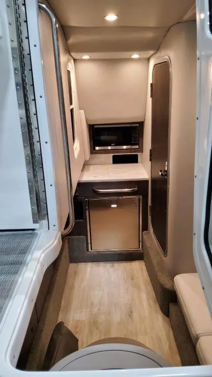 Slide: The Image of 2022 Formula 350 Crossover Bowrider interior cabin with kitchenette and seating area. - 10