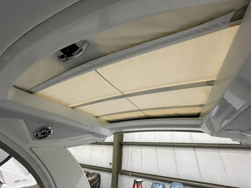 Slide: The Image of 2022 Formula 350 Crossover Bowrider retractable roof detail in a boat storage facility. - 18