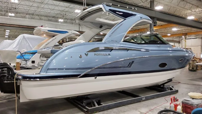 Slide: The Image of 2022 Formula 350 Crossover Bowrider in a showroom, side view. - 2