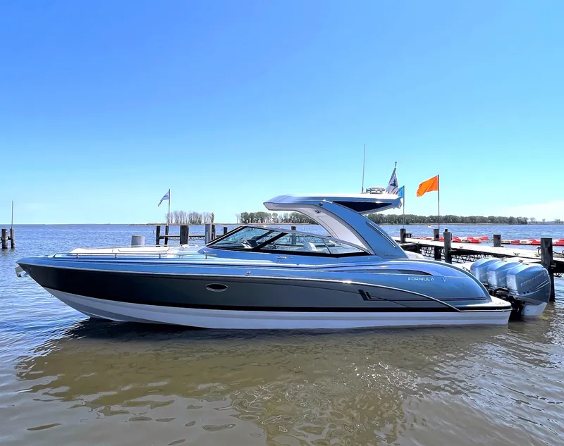 Slide: The Image of 2022 Formula 350 Crossover Bowrider boat on calm water near a dock. - 4