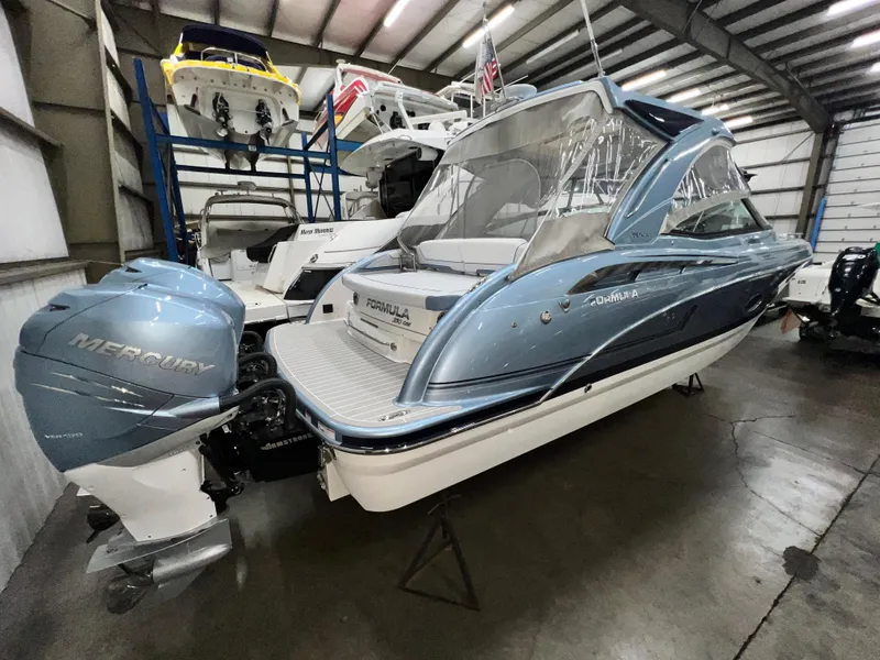 Slide: The Image of 2022 Formula 350 Crossover Bowrider in a showroom, featuring twin Mercury outboard engines. - 6