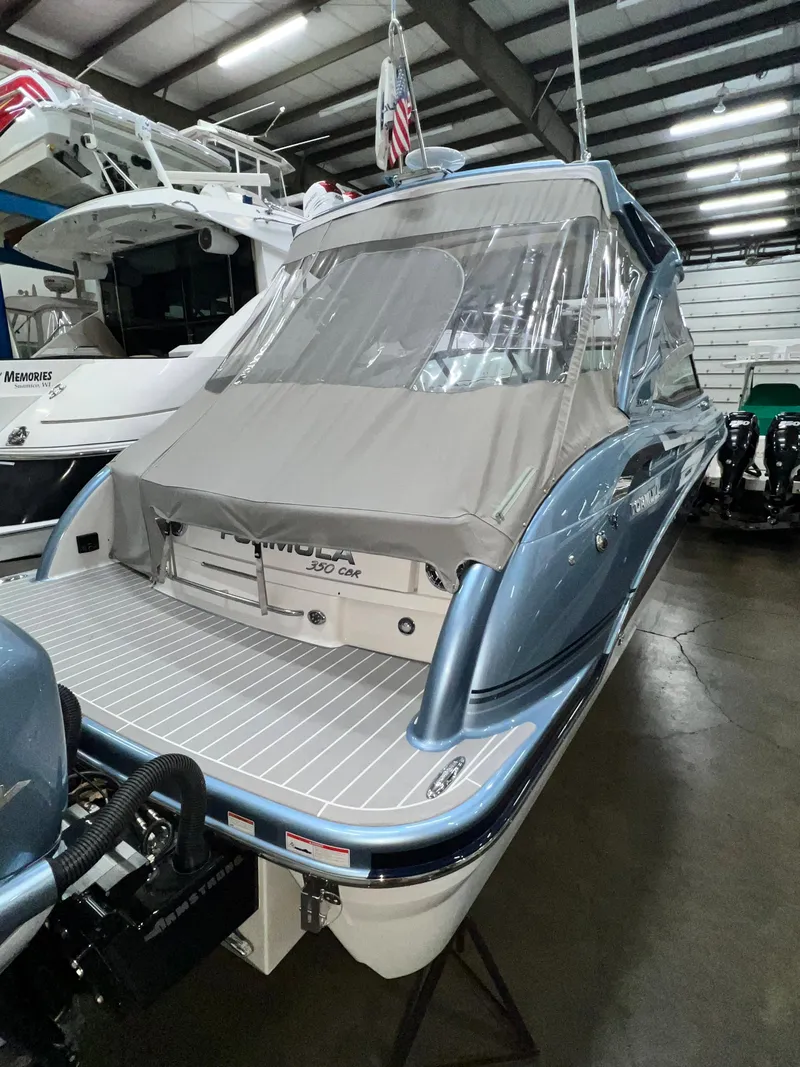 Slide: The Image of 2022 Formula 350 Crossover Bowrider in a showroom, rear view with cover. - 7