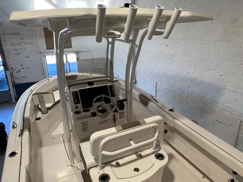 Slide: The Image of 2023 Robalo R222 Center Console boat interior with steering wheel and rod holders. - 11