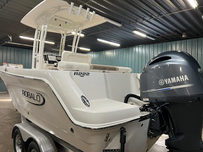 Slide: The Image of 2023 Robalo R222 Center Console boat with Yamaha outboard motor in a storage facility. - 4