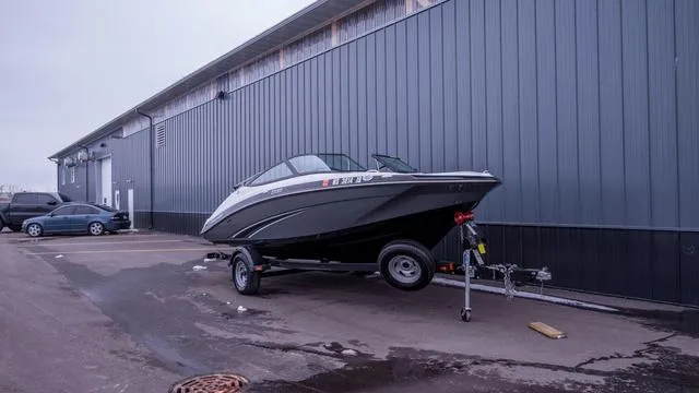 The Image of 2014 Yamaha SX192 on a trailer parked in front of a gray building. - 1