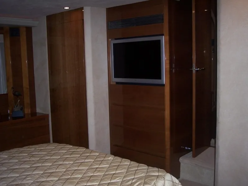 Slide: The Image of Luxurious bedroom interior of 2006 Princess V70 yacht with TV and wooden cabinetry. - 24