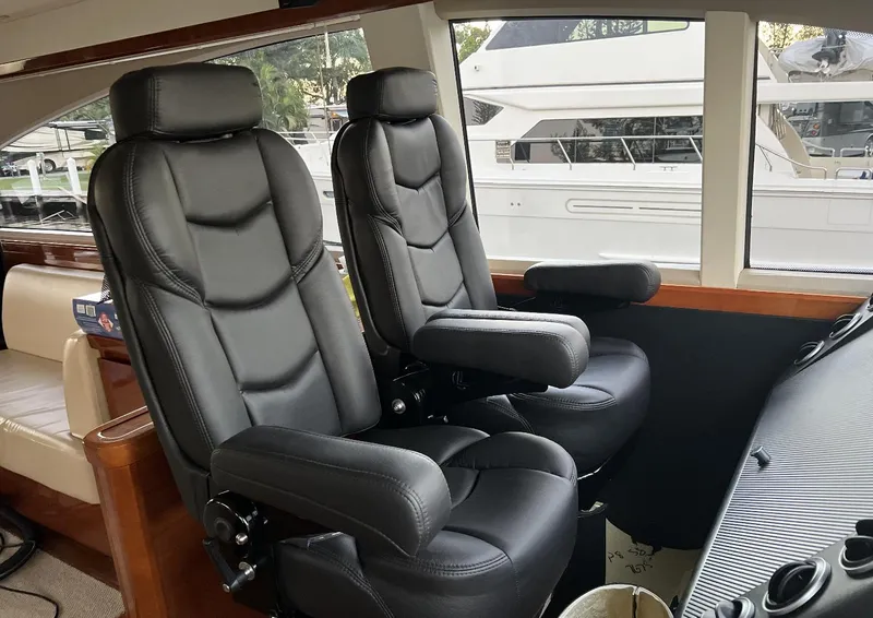 Slide: The Image of Luxury seating in 2006 Princess V70 yacht cockpit, featuring black leather captain chairs. - 8