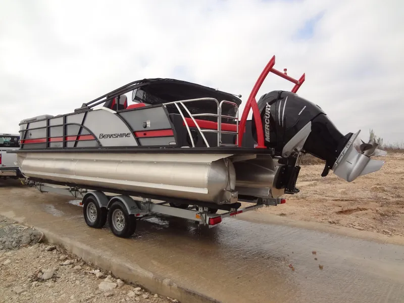 Slide: The Image of 2023 Berkshire 25UL STS 3.0+ pontoon boat on trailer, featuring Mercury outboard motor. - 7