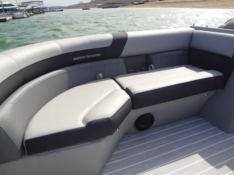 Slide: The Image of 2023 Berkshire 24UL CTS 3.0 boat interior with gray seating and waterfront view. - 13