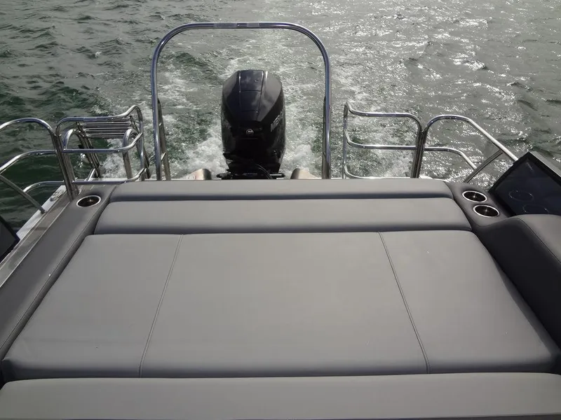 Slide: The Image of 2023 Berkshire 24UL CTS 3.0 boat with rear seating and outboard motor on water. - 27