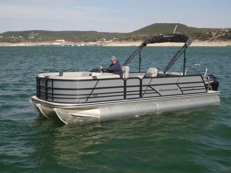 Slide: The Image of 2023 Berkshire 24UL CTS 3.0 pontoon boat on a lake with scenic hills in the background. - 6