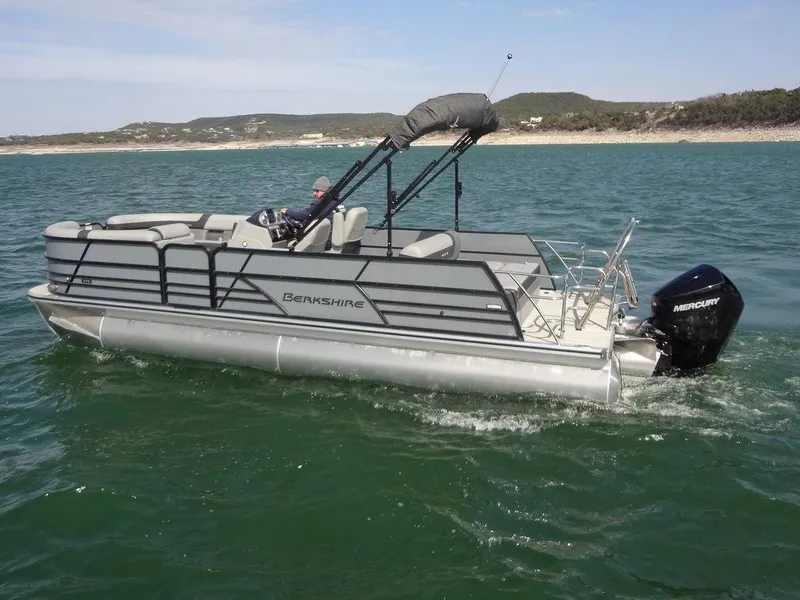 Slide: The Image of 2023 Berkshire 24UL CTS 3.0 pontoon boat cruising on a lake. - 7