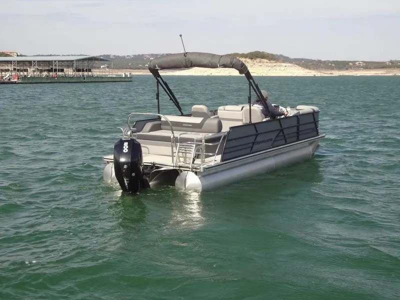 Slide: The Image of 2023 Berkshire 24UL CTS 3.0 pontoon boat on a calm lake. - 9