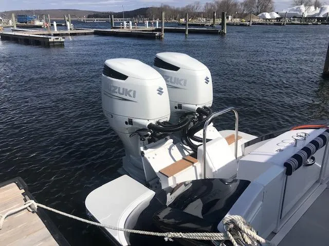 Slide: The Image of 2023 True North 34 Outboard Express boat with twin Suzuki engines docked. - 13
