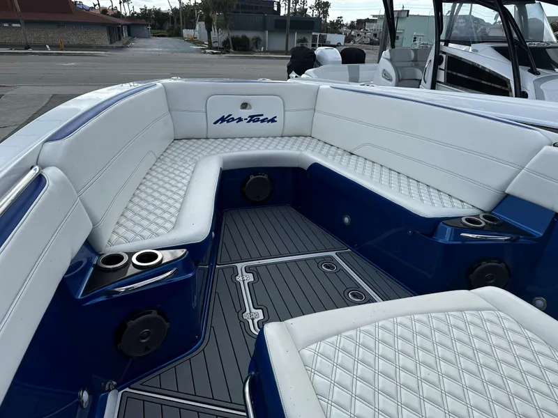 Slide: The Image of 2017 Nor-Tech 390 Center Console with white and blue seating, cup holders, and speakers. - 13