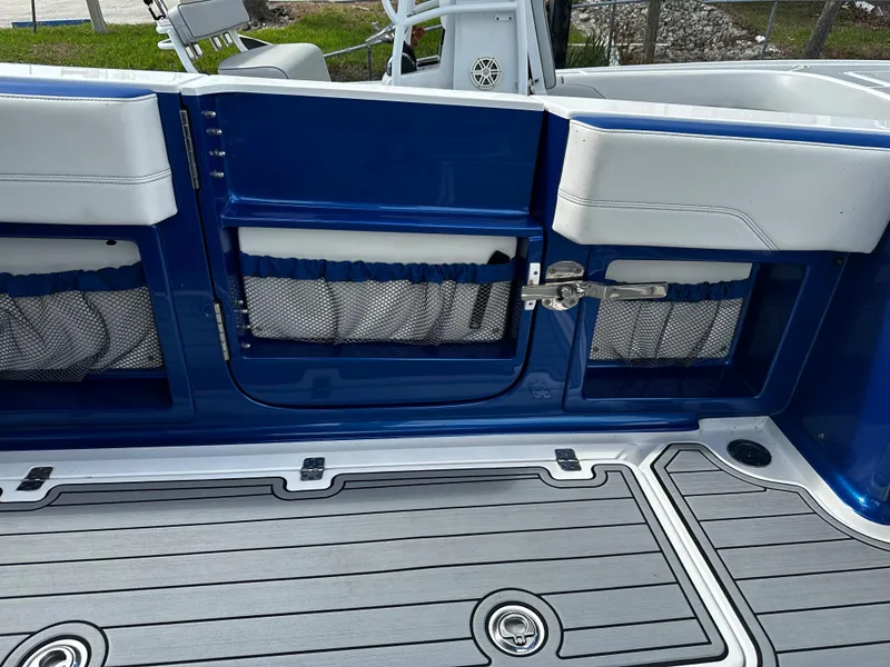 Slide: The Image of 2017 Nor-Tech 390 Center Console boat interior with blue and white seating and storage compartments. - 16